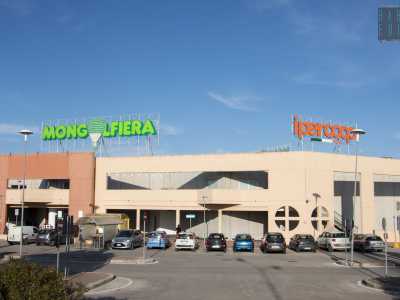 Giriamo cos� a destra per entrare nell�area dove si trovano i negozi pi� frequentati: Leroy Merlin, Mediaworld, Ipercoop e Mongolfiera, quest�ultimo il primo grande magazzino ad essere stato inaugurato, nel 2003. A dominare sono le gigantesche insegne dai colori sgargianti e i parcheggi affollati